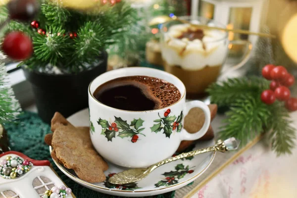 A cup of Christmas coffee, gingerbread cookies and tiramisu dessert on windowsill