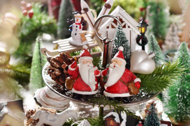 İki Noel Baba heykelciği ve katlı tepside diğer süslemelerle Noel süslemeleri. 