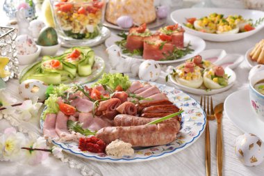 Geleneksel Polonya beyaz sosisi ve soğuk pirzola ile Paskalya kahvaltısı, baharatlı yumurta, sebze salatası ve bayram masasında hamur işleri.