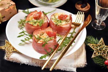 Sebze salatası ve parma jambonuna sarılmış mayonez. Noel için siyah masada.