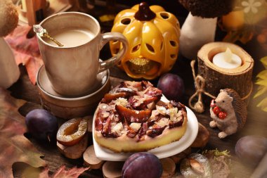 Kalp şeklinde badem taneli ev yapımı erikli cheesecake ve kırsal tarzda ahşap masada bir fincan latte kahve.