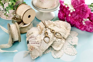 Kaliteli el yapımı kalpler, dikiş malzemeleri ve masada duran dantel süsler.