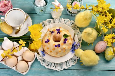 Geleneksel halka kek mavi ahşap masa üzerinde limon kremalı yumurta, 3 tavuk ve süslemeli 