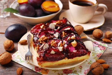 Badem gevreği ve cevizli ev yapımı erikli kek, bir fincan kahve ve taze meyve.