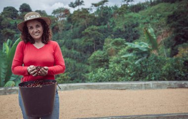 Kahve çekirdeklerini elleriyle gösteren bir kadın.