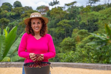 Kahve çekirdeklerini elleriyle gösteren bir kadın.