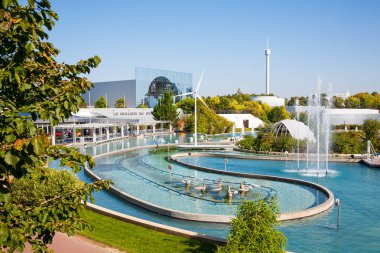 Poitiers, France - September 22 2010: Pool and fountains in front of IMAX Cinema pavilion in Futuroscope theme park clipart