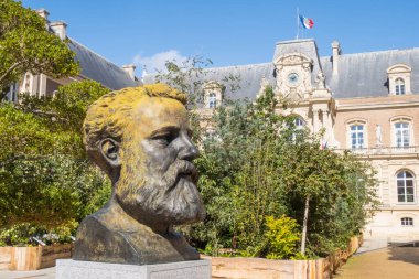 City Hall and bronze buste of Jules Verne, famous French writer and adventurer, by artist and sculptor Philippe Arnault clipart