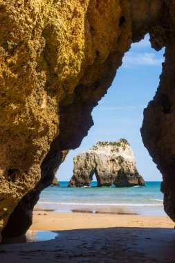 Plaj, Portekiz 'in güneyindeki Algarve bölgesinde Portimao yakınlarındaki kaya kesiğinden dikey olarak fotoğraflandı.