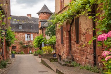 Collonges-la-Rouge, Fransa - 19 Haziran 2024: Fransa 'da Collonges-la-Rouge' daki sokakları ve kırmızı evleri ziyaret etmek, Correze