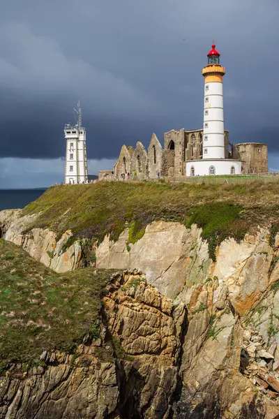 Saint-Mathieu de Fine-Terre Manastırı 'nın harabeleri ve kayaya bakan deniz feneri, Finistere, Brittany, Fransa