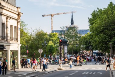 Paris, Fransa - 22 Haziran 2025: Paris 'teki Notre-Dame Katedrali' nin yeniden inşası gündüz vakti Rue du Renard Caddesi 'nden vinç ve Paris' in 4. arrondissement 'inde sokakta yürüyen insanlarla fotoğraflandı.