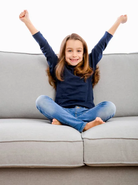 Ευτυχισμένο Κοριτσάκι Που Κάθεται Στον Καναπέ Δύο Χέρια Ψηλά Royalty Free Εικόνες Αρχείου