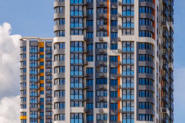Mavi gökyüzü arka planında beyaz bulutlu, yeni inşa edilmiş apartmanlar..