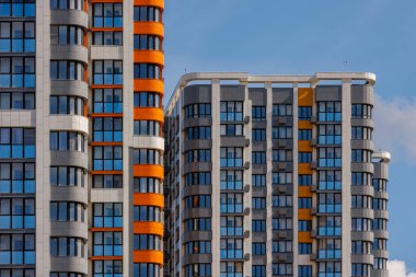 Mavi gökyüzü arka planında beyaz bulutlu, yeni inşa edilmiş apartmanlar..