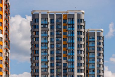 Mavi gökyüzü arka planında beyaz bulutlu, yeni inşa edilmiş apartmanlar..