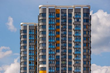 Mavi gökyüzü arka planında beyaz bulutlu, yeni inşa edilmiş apartmanlar..