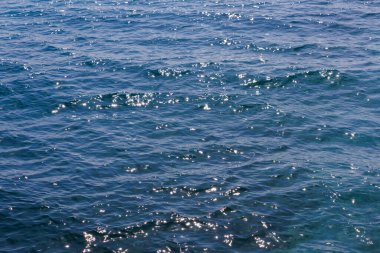 Genel sınırsız deniz suyu yüzeyi, gündüzleri sadece mavi su ve hafif dalgalı vavralar..