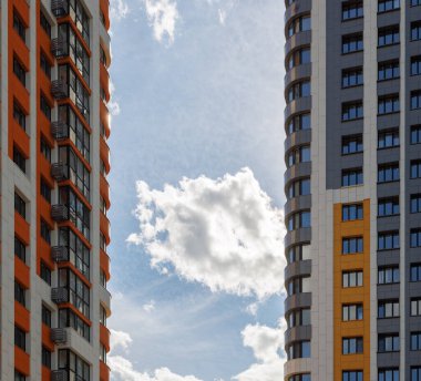 Mavi gökyüzü arka planında beyaz bulutlu, yeni inşa edilmiş apartmanlar..