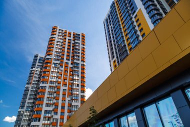 Mavi gökyüzü arka planında beyaz bulutlu, yeni inşa edilmiş apartmanlar..