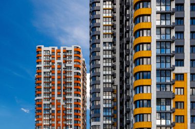 Mavi gökyüzü arka planında beyaz bulutlu, yeni inşa edilmiş apartmanlar..