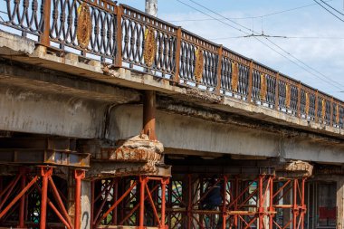 Eski Sovyet otomotiv köprüsü tamir süreci kırmızı iskeleler ve destekleyici yapılar ile.