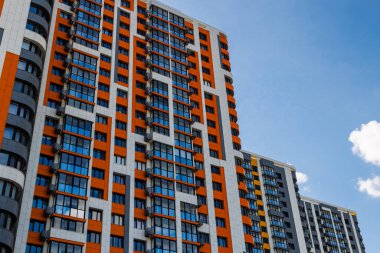 Mavi gökyüzü arka planında beyaz bulutlu, yeni inşa edilmiş apartmanlar..