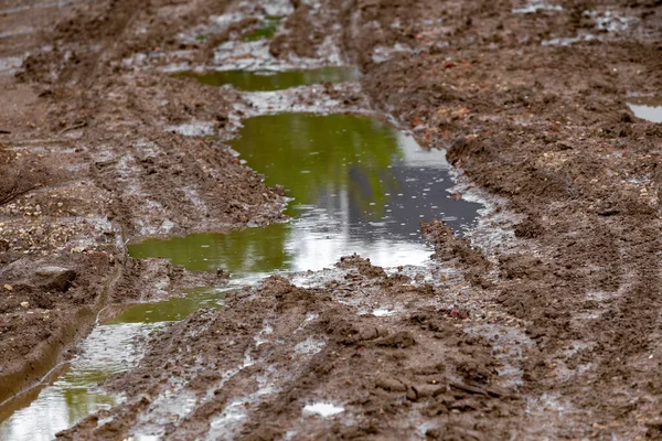 stock image puddle in dirt road at summer day, closeup with selective focus.