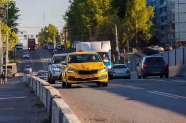 23 Mayıs 2022 'de Rusya, Tula' da yaz günü araba trafiği olan sarı bir taksi.