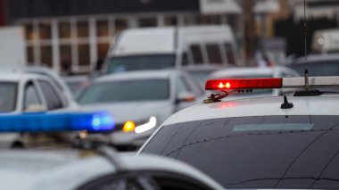 Bulutlu bir günde şehir caddesinde polis arabaları yanıyor. Kapatın.
