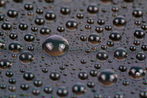 water drops on surface of screen of modern cellphone, close-up with selective focus and blur