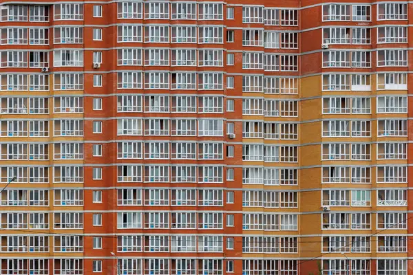 large cheap russian new apartment building wall with enormous quantity of windows, full-frame background and texture