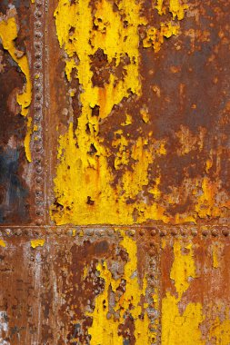 Çok güzel paslanmış, perçinlenmiş, sarı boya artığı ve düz çerçeve arka planı olan metal levhalar..