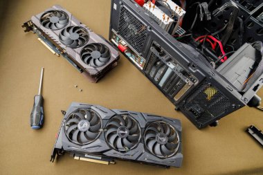 Grafik kartı güncelleme konsepti, Rusya, Tula 'da bronz kumaş arka planında ATX PC dosyası yakınında iki oyun grafikleri kartı - 27 Temmuz 2022