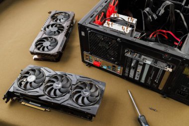 Grafik kartı güncelleme konsepti, Rusya, Tula 'da bronz kumaş arka planında ATX PC dosyası yakınında iki oyun grafikleri kartı - 27 Temmuz 2022