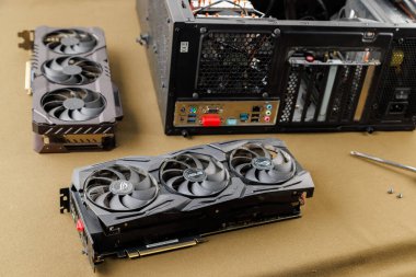 Grafik kartı güncelleme konsepti, Rusya, Tula 'da bronz kumaş arka planında ATX PC dosyası yakınında iki oyun grafikleri kartı - 27 Temmuz 2022