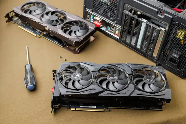 Grafik kartı güncelleme konsepti, Rusya, Tula 'da bronz kumaş arka planında ATX PC dosyası yakınında iki oyun grafikleri kartı - 27 Temmuz 2022