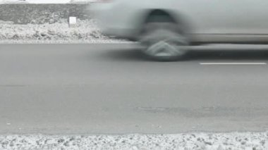 Karlı kış yolu boyunca giden arabalar beton bariyerlerle bölünmüş, yakın görüş.