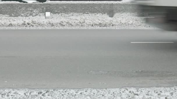 雪に覆われた冬の道を運転する車はコンクリートの障壁 近い側面の眺めと分けました — ストック動画