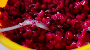 Plastik kasede kaşık ile doğranmış kırmızı pancar salatası..