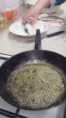 Kıdemli Kafkas kadınlarının elleri hamamböceğini una batırır ve ev mutfağındaki ocakta kızartmak için yağlı bir tavaya koyar..