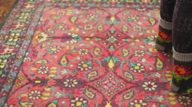 Süslü, süslü kırmızı halıda sıcak yün çoraplar..