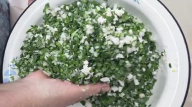 Kafkas kadın elleri mutfaktaki diş mineli havuzda jusai ve soğan karıştırıyor..