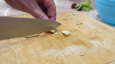 Beyaz eller bambudan karanfil kesiyor yerli mutfağın tahtalarını kesiyor, geniş açı yavaş çekimde. Kullanıcı tarafından oluşturulan gerçek yaşam içeriği.