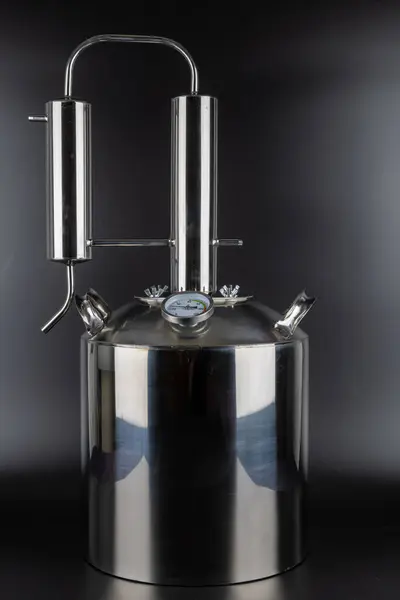 stock image brand new stainless steel alcohol machine or moonshine still on black background.