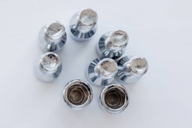 Beyaz arka planda parlak, çelik kaplamalı civatalar, tam kare, yüksek açı, gerçek fotoğraf.