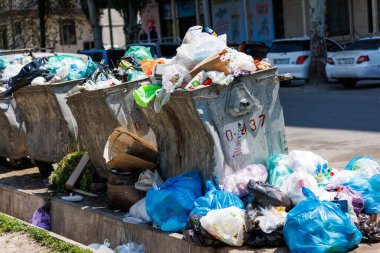 overfilled public trash bins at summer day in Bishkek, Kyrgyzstan - May 26, 2023 clipart