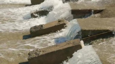 Bir sıra paraşüt, beton su sızıntısı kanalındaki blokları dengeleyerek suyun akışını yavaşlatır..