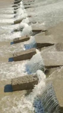 Bir sıra paraşüt, beton su sızıntısı kanalındaki blokları dengeleyerek suyun akışını yavaşlatır..