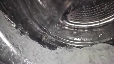 Çamaşır makinesine su sıçratan süper yavaş çekim, cep telefonuyla yapılan videodaki ağır ara polasyon objeleri.